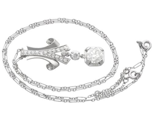 fig 6. An Art Deco platinum pendant set with brilliant-cut diamonds featuring a geometric ribbon motif suspended above a central diamond drop.