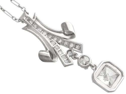 fig 8. An Art Deco platinum pendant set with brilliant-cut diamonds featuring a geometric ribbon motif suspended above a central diamond drop.