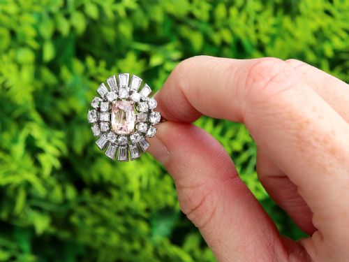 fig 1. A platinum cluster ring featuring a cushion-cut pink sapphire set in yellow gold claws surrounded by diamond halos.