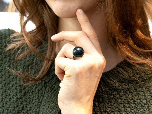 fig 3. An antique circular bloodstone cabochon ring featuring a central inset diamond, mounted in 14ct white gold with green gem-set shoulders.