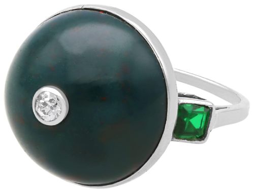 fig 6. An antique circular bloodstone cabochon ring featuring a central inset diamond, mounted in 14ct white gold with green gem-set shoulders.