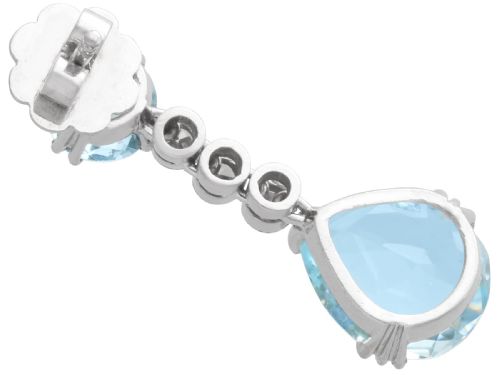 fig 6. A pair of 14ct white gold drop earrings featuring round and pear-cut light blue aquamarines joined by a vertical line of small round diamonds.