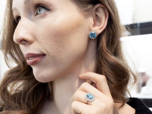fig 3. A pair of 14ct white gold stud earrings featuring round blue zircon gemstones encircled by diamond halos with millegrain borders.