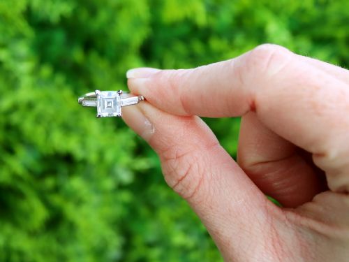 fig 1. An Art Deco platinum ring featuring a central square step-cut diamond set between two horizontal baguette side stones.
