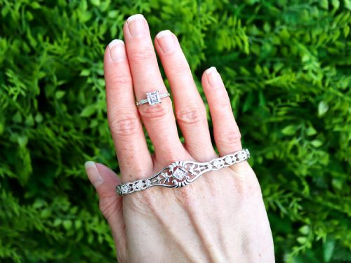 fig 2. An Art Deco platinum ring featuring a central square step-cut diamond set between two horizontal baguette side stones.