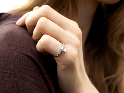 fig 4. An Art Deco platinum ring featuring a central square step-cut diamond set between two horizontal baguette side stones.