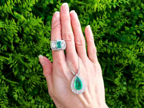 fig 2. An Art Deco platinum cocktail ring set with a central rectangular emerald flanked by round diamonds and baguette diamonds.