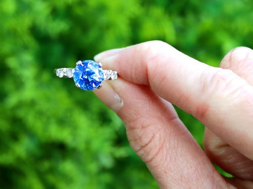 fig 1. A round blue sapphire set in a platinum band flanked by round diamonds on each side.