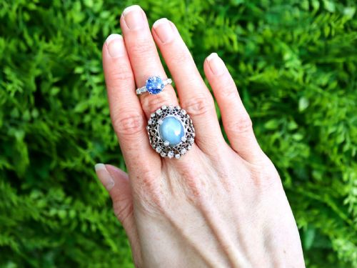 fig 2. A round blue sapphire set in a platinum band flanked by round diamonds on each side.