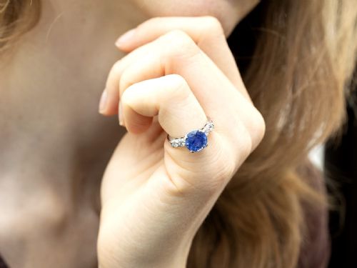 fig 4. A round blue sapphire set in a platinum band flanked by round diamonds on each side.