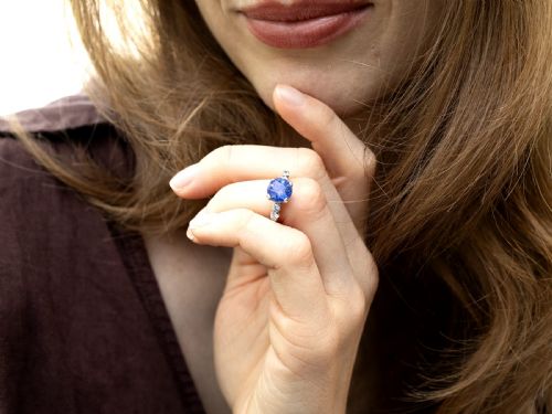 fig 5. A round blue sapphire set in a platinum band flanked by round diamonds on each side.