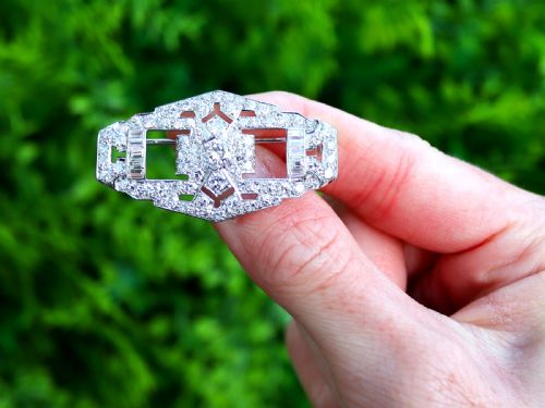 fig 1. An Art Deco platinum plaque brooch featuring an intricate geometric openwork setting encrusted with round and baguette cut diamonds.