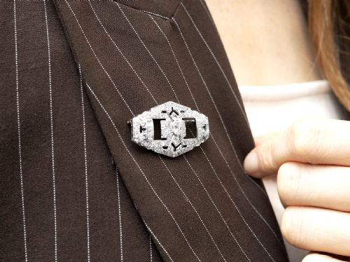 fig 5. An Art Deco platinum plaque brooch featuring an intricate geometric openwork setting encrusted with round and baguette cut diamonds.
