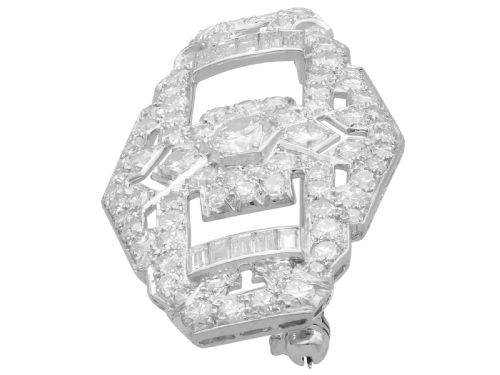 fig 6. An Art Deco platinum plaque brooch featuring an intricate geometric openwork setting encrusted with round and baguette cut diamonds.