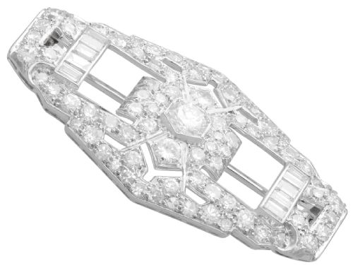 fig 7. An Art Deco platinum plaque brooch featuring an intricate geometric openwork setting encrusted with round and baguette cut diamonds.