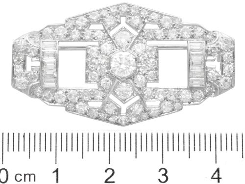 fig 10. An Art Deco platinum plaque brooch featuring an intricate geometric openwork setting encrusted with round and baguette cut diamonds.