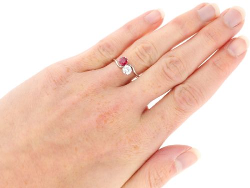 fig 7. An Art Deco platinum twist ring featuring a circular red Burmese ruby and a brilliant white diamond set side by side on a curved band.