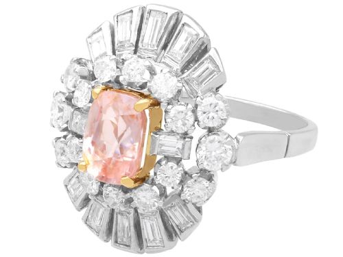 fig 9. A platinum cluster ring featuring a cushion-cut pink sapphire set in yellow gold claws surrounded by diamond halos.
