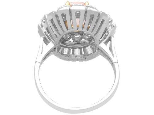 fig 10. A platinum cluster ring featuring a cushion-cut pink sapphire set in yellow gold claws surrounded by diamond halos.