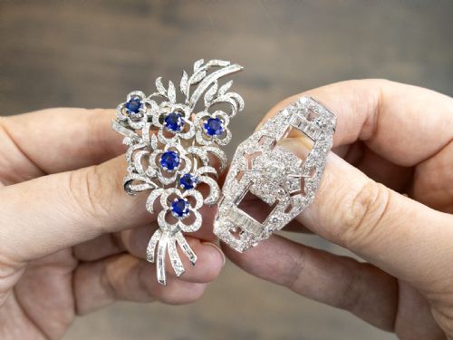 fig 4. An Art Deco platinum brooch styled as a floral spray, set with round blue sapphires and accented with pave and baguette-cut diamonds.