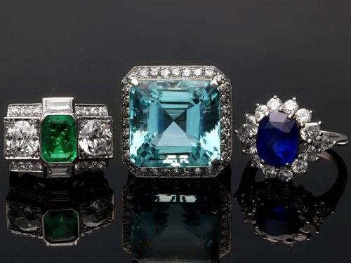 fig 7. An Art Deco platinum cocktail ring set with a central rectangular emerald flanked by round diamonds and baguette diamonds.