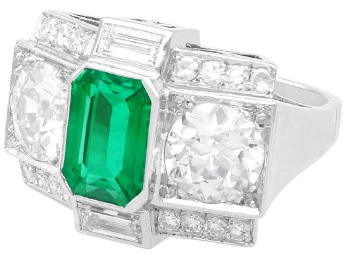 fig 8. An Art Deco platinum cocktail ring set with a central rectangular emerald flanked by round diamonds and baguette diamonds.