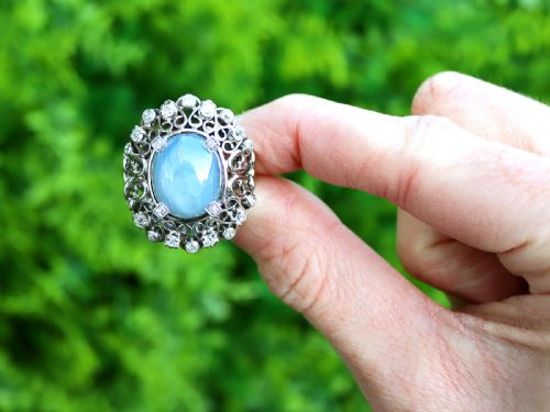 fig 1. An oval cabochon blue star sapphire set in platinum surrounded by an intricate openwork diamond halo.
