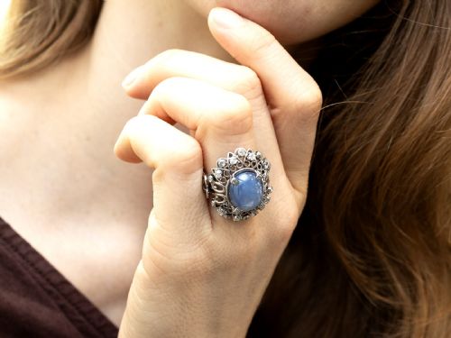 fig 3. An oval cabochon blue star sapphire set in platinum surrounded by an intricate openwork diamond halo.