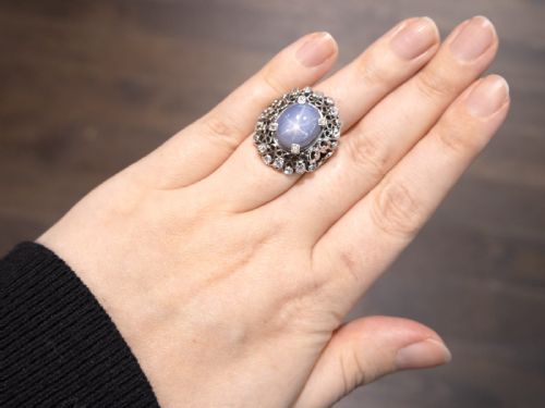 fig 4. An oval cabochon blue star sapphire set in platinum surrounded by an intricate openwork diamond halo.