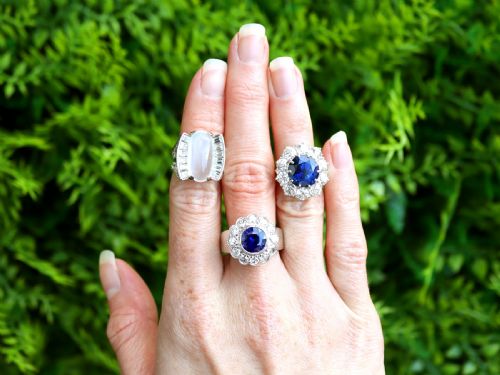 fig 2. A round deep blue sapphire framed by a halo of ten round brilliant diamonds on an 18ct yellow gold band.
