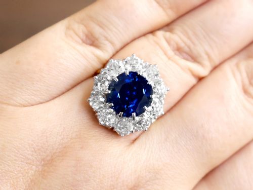 fig 4. A round deep blue sapphire framed by a halo of ten round brilliant diamonds on an 18ct yellow gold band.