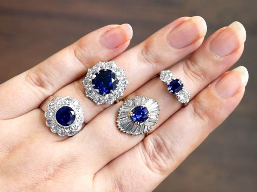 fig 5. A round deep blue sapphire framed by a halo of ten round brilliant diamonds on an 18ct yellow gold band.