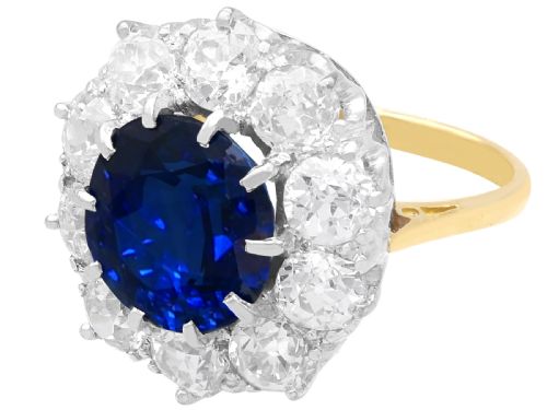 fig 7. A round deep blue sapphire framed by a halo of ten round brilliant diamonds on an 18ct yellow gold band.