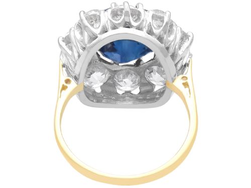 fig 8. A round deep blue sapphire framed by a halo of ten round brilliant diamonds on an 18ct yellow gold band.