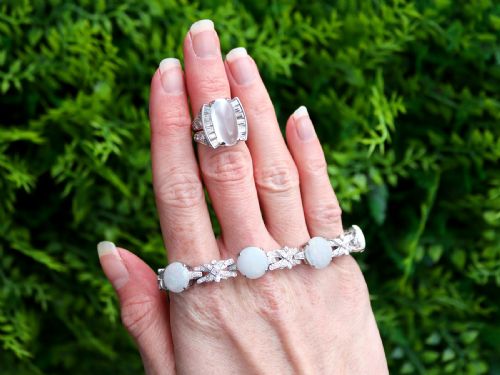 fig 3. An Art Deco platinum dress ring featuring a central oval cabochon moonstone flanked by stepped baguette-cut diamonds.