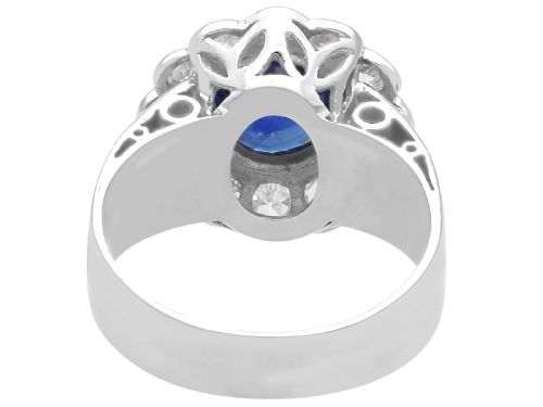 fig 9. A vintage 18ct white gold cluster ring set with a central round blue sapphire surrounded by a halo of brilliant diamonds with a scalloped edge.