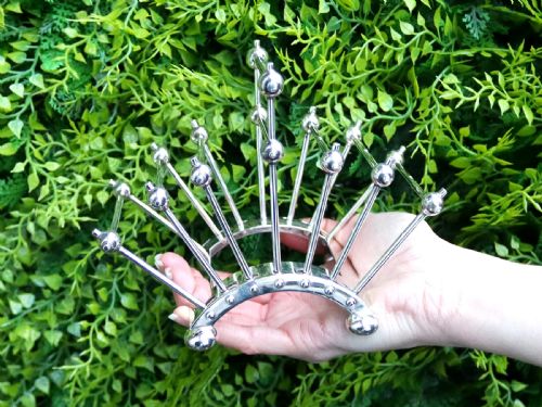 fig 2. An Edwardian sterling silver toast rack featuring a curved base and fan-shaped radiating dividers topped with spherical details.