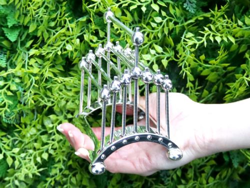 fig 3. An Edwardian sterling silver toast rack featuring a curved base and fan-shaped radiating dividers topped with spherical details.