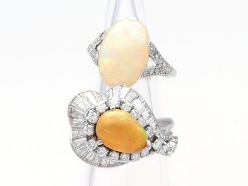 fig 7. A platinum dress ring featuring a central pear-shaped orange opal surrounded by a halo of round and baguette-cut diamonds in an asymmetrical frame.
