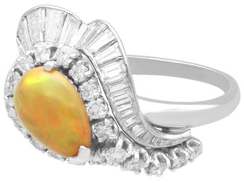fig 8. A platinum dress ring featuring a central pear-shaped orange opal surrounded by a halo of round and baguette-cut diamonds in an asymmetrical frame.