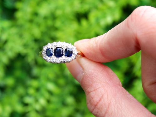 fig 1. An 18ct yellow gold Victorian trilogy ring featuring three blue sapphires framed by a border of small diamonds.