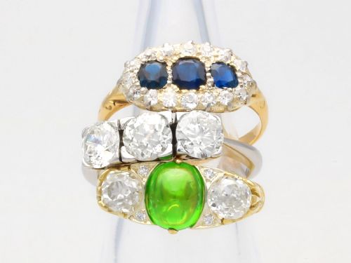fig 4. An 18ct yellow gold Victorian trilogy ring featuring three blue sapphires framed by a border of small diamonds.