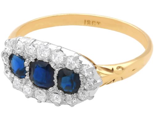 fig 6. An 18ct yellow gold Victorian trilogy ring featuring three blue sapphires framed by a border of small diamonds.