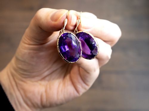 fig 2. A pair of antique 9ct gold drop earrings featuring large oval faceted purple amethysts on leverback ear wires.