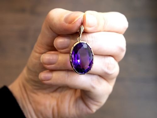 fig 3. A pair of antique 9ct gold drop earrings featuring large oval faceted purple amethysts on leverback ear wires.