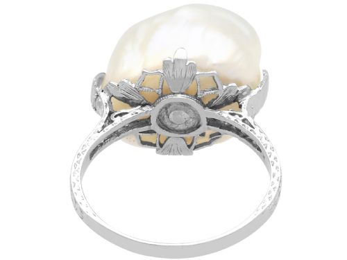 fig 9. An antique platinum dress ring featuring a large, smooth natural blister pearl flanked by diamond-set shoulders.