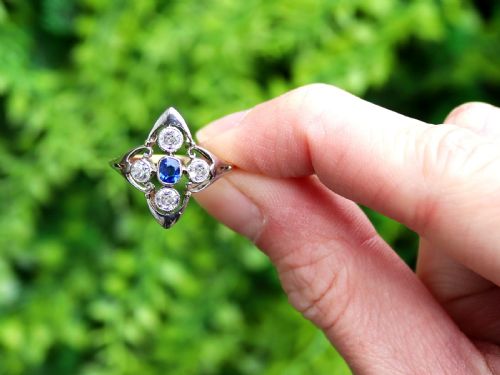 fig 1. An Art Deco 14ct yellow gold ring featuring a central oval blue sapphire surrounded by four round diamonds set in a diamond-shaped openwork frame.
