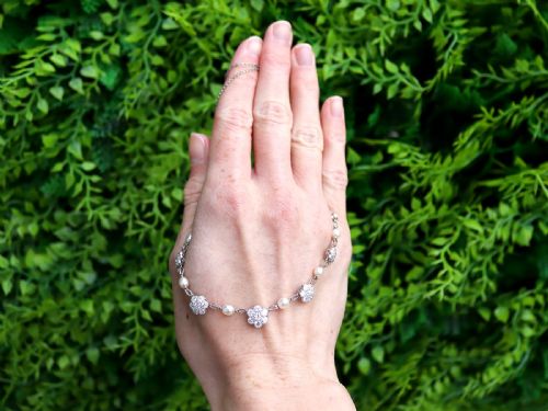 fig 2. An Edwardian platinum chain necklace set with diamond floral clusters and interspersed with round white pearls.
