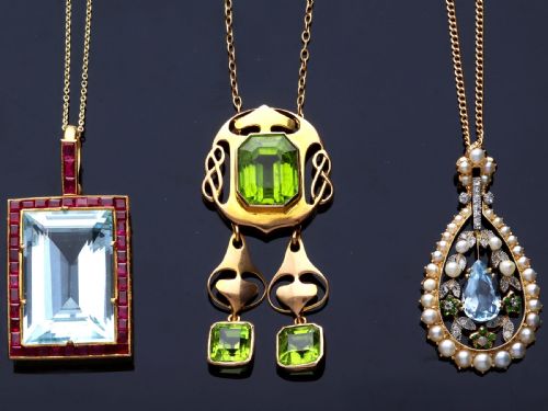 fig 5. A large rectangular step-cut blue aquamarine set in yellow gold with a square-cut red ruby border and ruby-set bail.