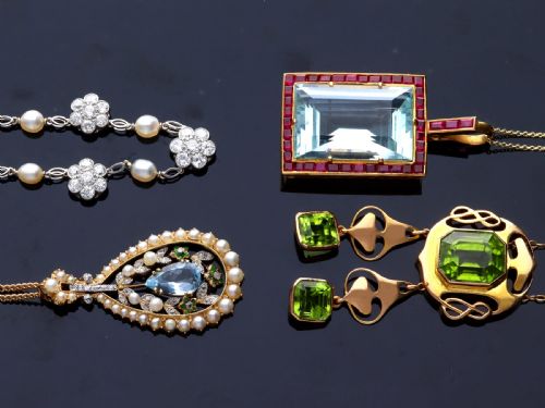 fig 6. A large rectangular step-cut blue aquamarine set in yellow gold with a square-cut red ruby border and ruby-set bail.